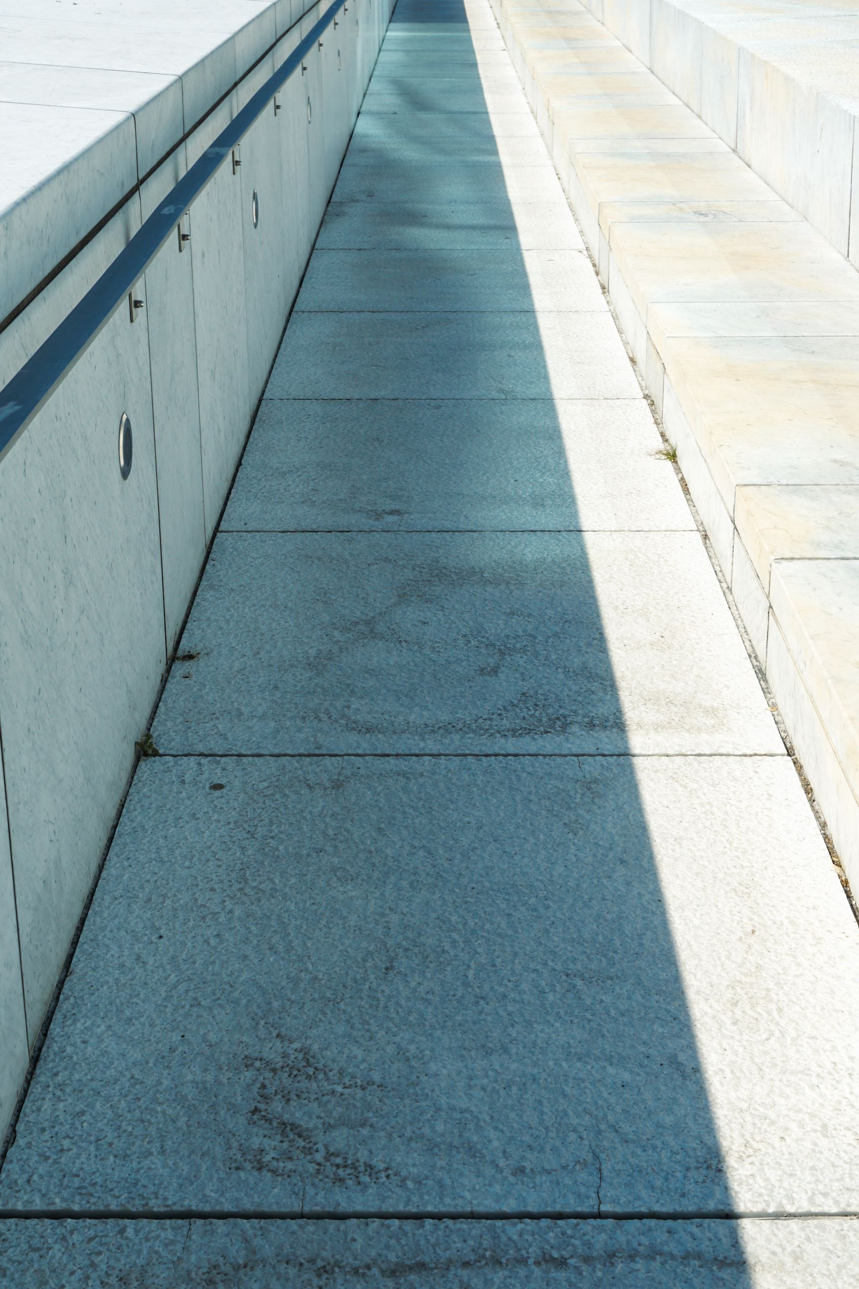 Explore the contrasting shadows and sunlight on a concrete walkway in urban Oslo, Norway.